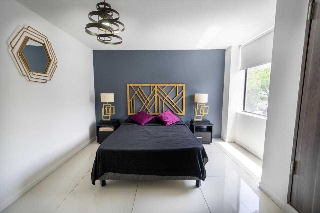 Habitación principal moderna con cama doble y decoración elegante en apartamento Medellín cerca Parque Lleras