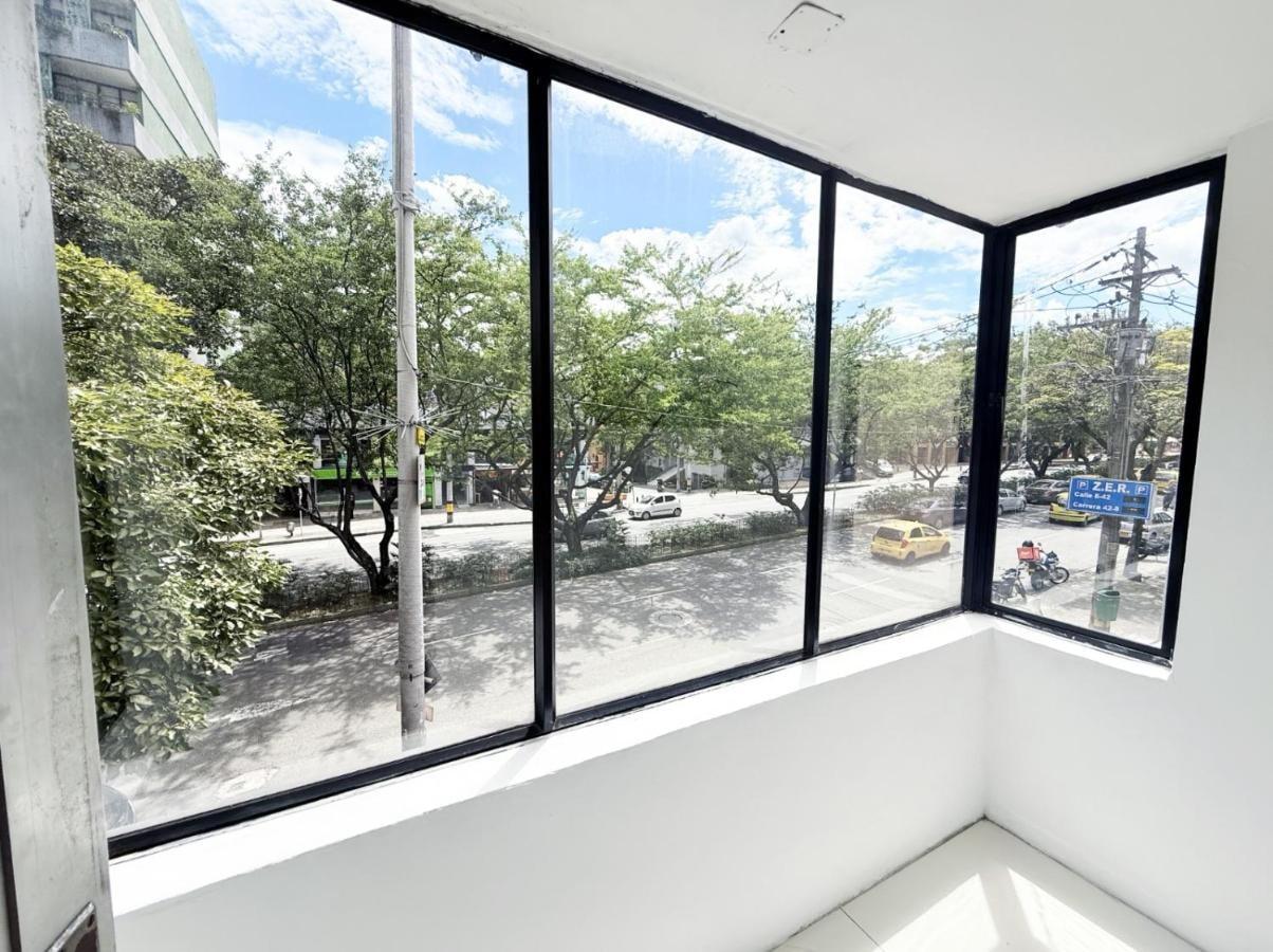 Vista panorámica desde ventana de apartamento cerca del Parque Lleras en Medellín con árboles y calles