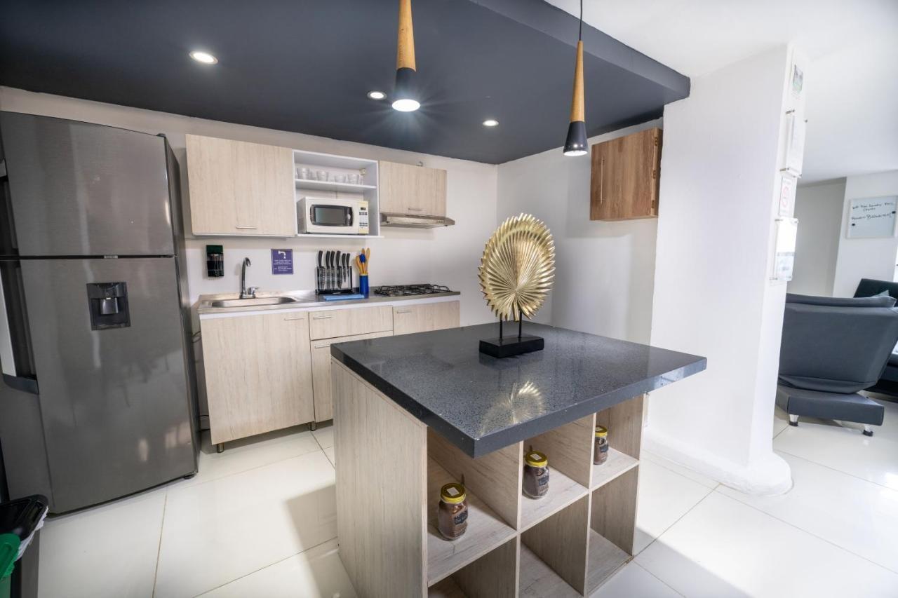 Cocina moderna con isla y electrodomésticos en apartamento cerca al Parque Lleras en Medellín