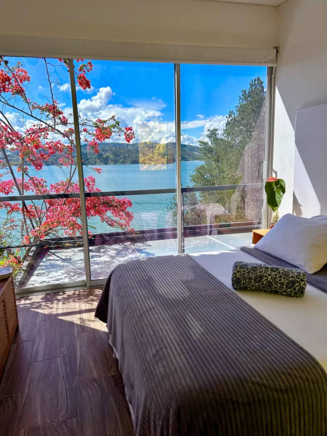 Habitación principal con vista panorámica al lago de Guatapé desde villa de lujo en Peñol