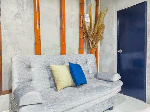 Sala de estar moderna con sofá gris y decoración en apartamento Salento Stay