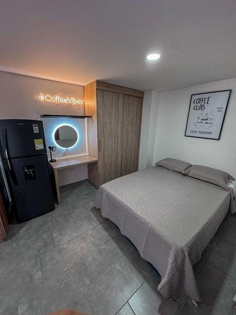 Habitación moderna con cama doble, nevera y escritorio en apartamento Salento Stay