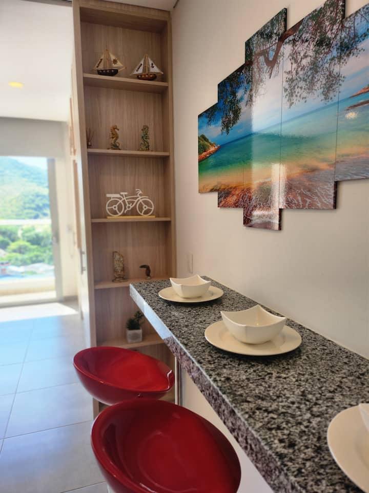 Cocina moderna con barra desayunador y decoración tropical en Premium Suite Santa Marta
