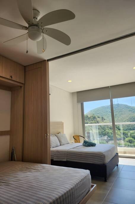 Habitación doble con camas individuales y balcón con vista a montañas en Premium Suite Santa Marta