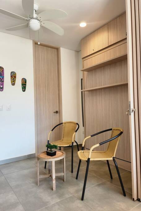 Área de descanso moderna con sillas de mimbre en suite premium con balcón Santa Marta