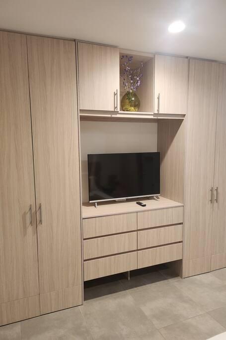 Sala moderna con muebles de madera y televisor en apartamento Premium Suite Santa Marta