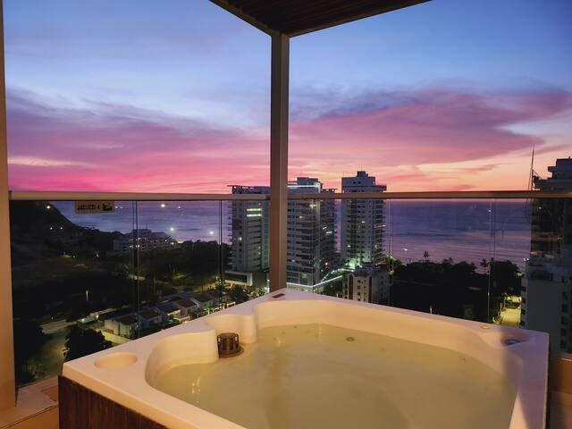 Balcón con jacuzzi y vista al mar al atardecer desde Premium Suite en Santa Marta
