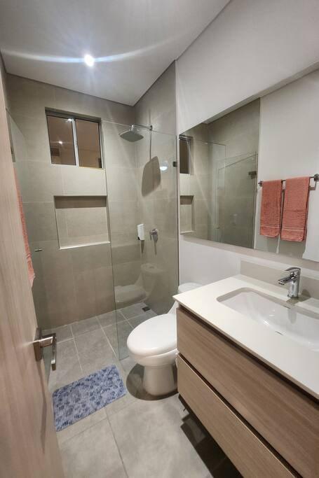 Baño moderno con ducha de vidrio y lavamanos doble en suite premium Santa Marta
