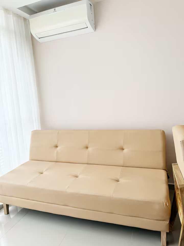 Sofá cama beige con aire acondicionado en sala de apartamento en Cartagena de Indias