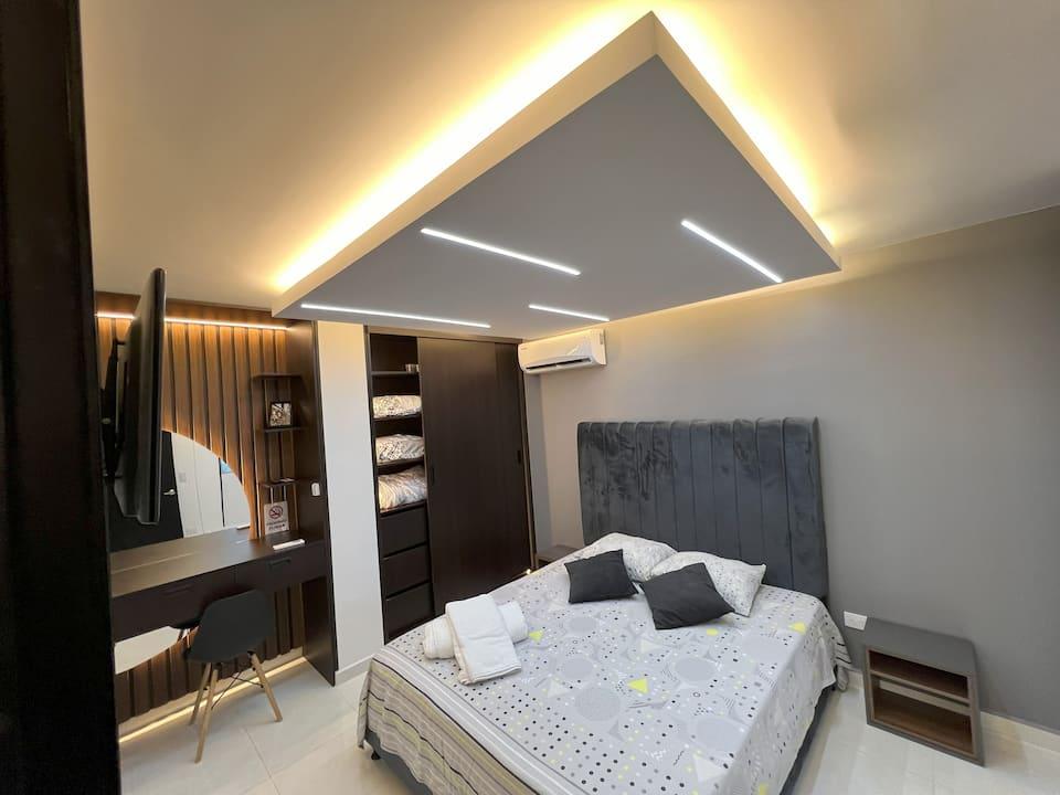 Habitación principal moderna con cama doble y techo LED en apartamento inteligente Cúcuta
