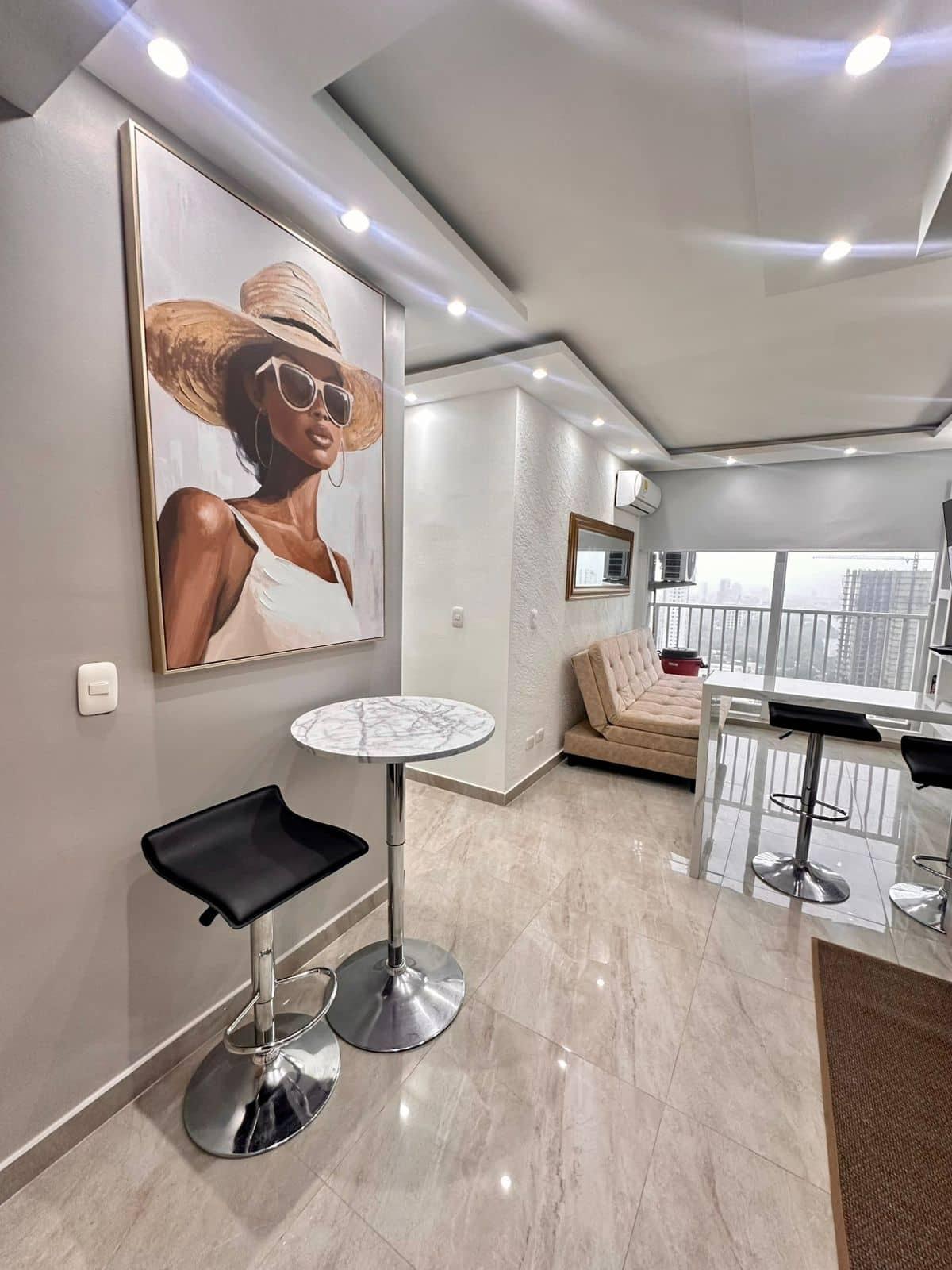 Sala comedor moderna con arte contemporáneo y mesa alta en apartamento céntrico Cartagena con vista al mar