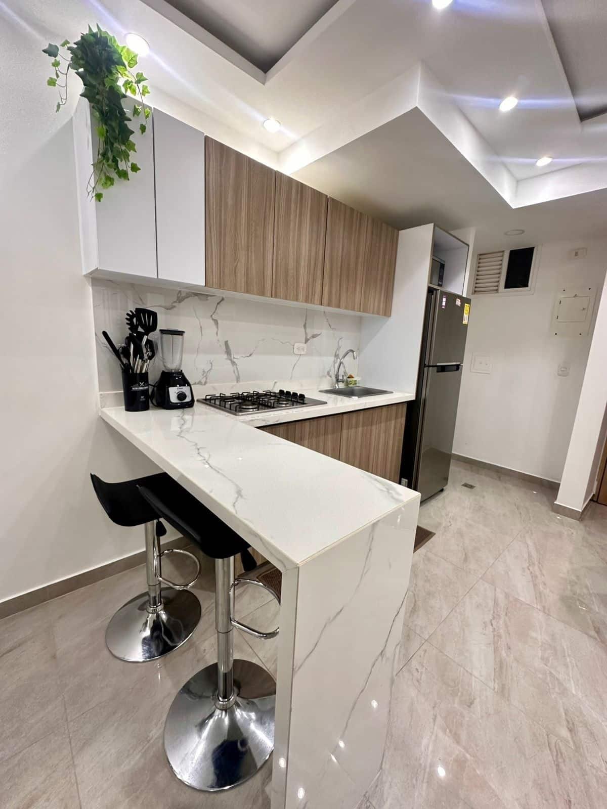 Cocina moderna con isla y taburetes en apartamento nuevo con vista al mar en Cartagena