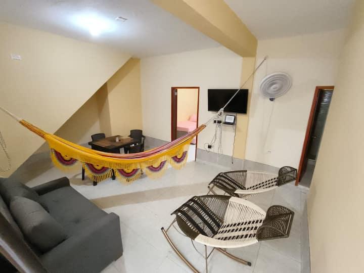 Sala moderna con hamaca colorida y sillas de mimbre en apartamento céntrico Cartagena cerca playa