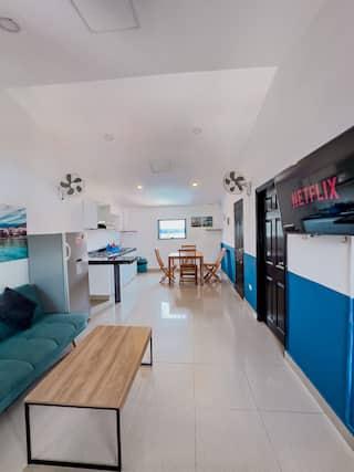 Sala y cocina moderna de apartamento en Cartagena con sofá turquesa y muebles contemporáneos