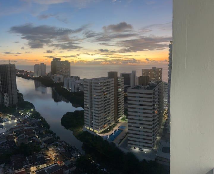 Vista panorámica desde apartamento en Cartagena al atardecer con edificios modernos y mar al fondo