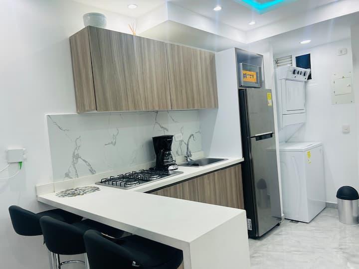 Cocina moderna con acabados en mármol y madera en apartamento de Cartagena cerca de la playa