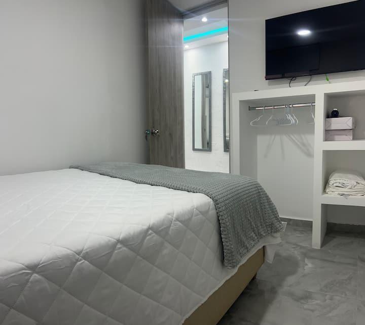 Habitación moderna con cama doble y TV en apartamento céntrico de Cartagena cerca playa