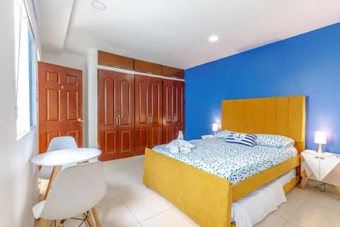 Habitación principal con cama amarilla y pared azul en apartamento de Cartagena cerca a la playa