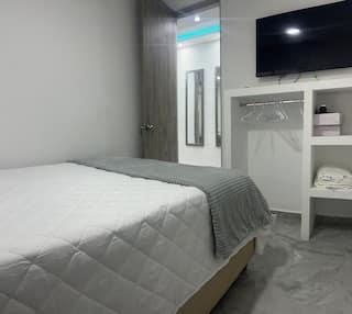 Habitación moderna con cama doble, TV y armario en apartamento céntrico de Cartagena