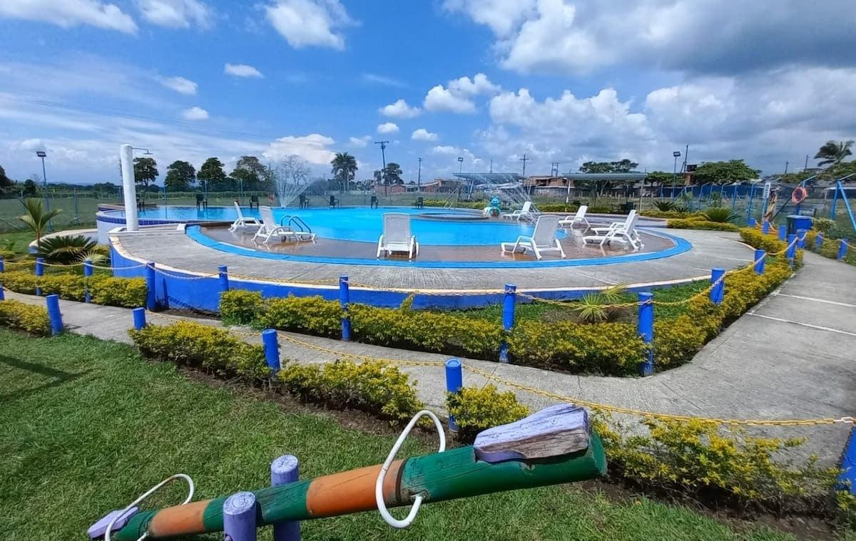 Piscina con zona de descanso y paisajismo en ApartHotel Nathalie Montenegro Quindío