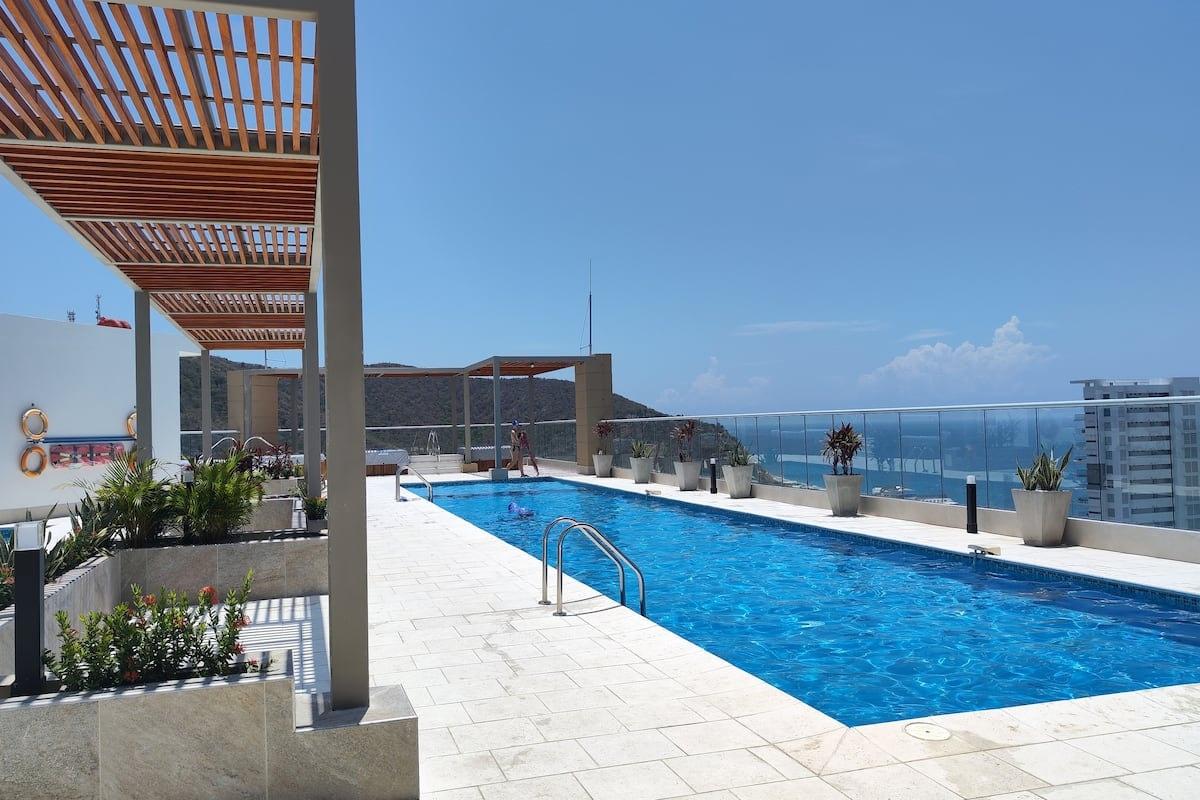 Piscina en terraza de apartamento en Santa Marta con vista al mar Caribe y pergola de madera