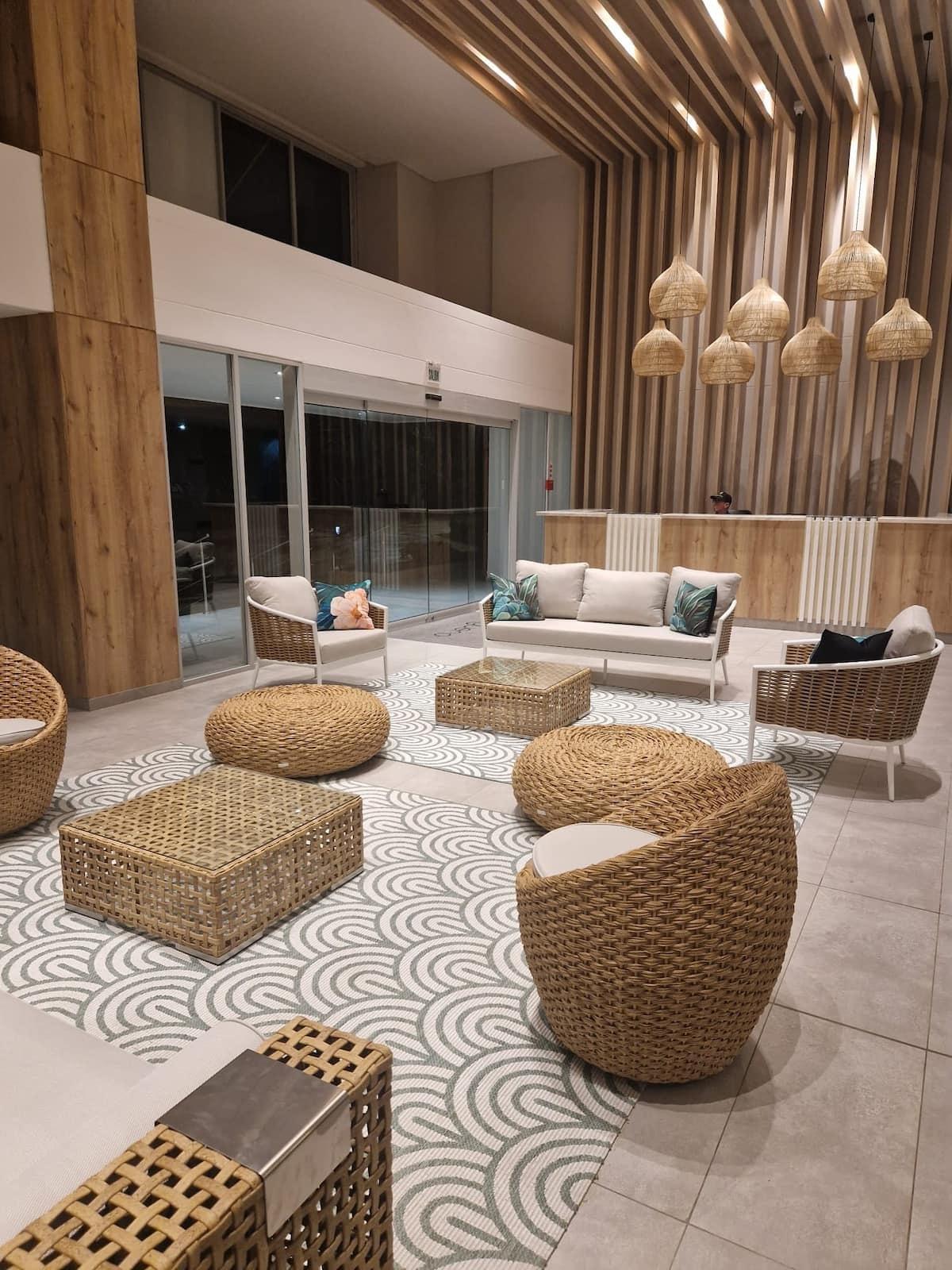 Lobby moderno con muebles de mimbre y decoración natural en apartamento Santa Marta cerca playa