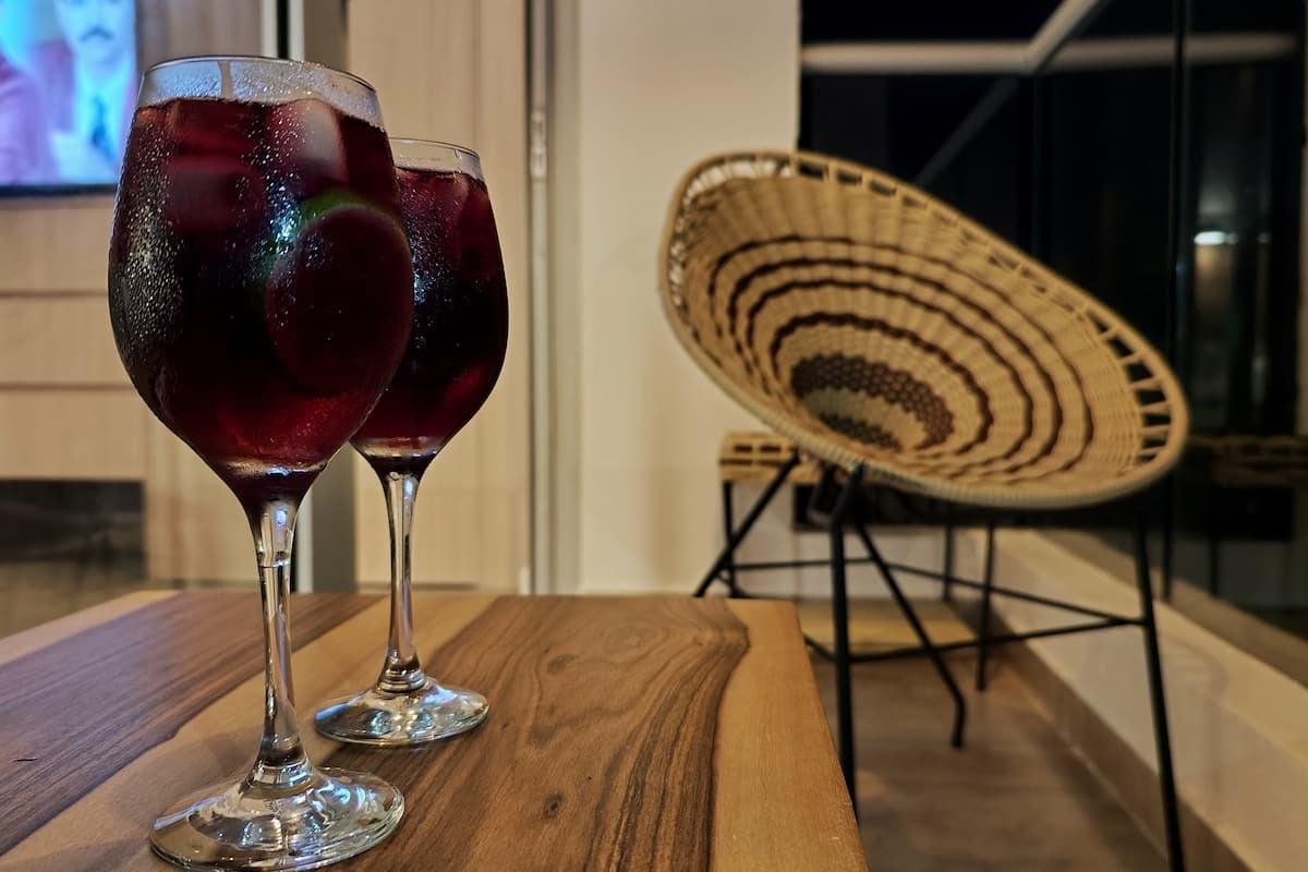 Copas de vino tinto servidas en mesa de madera en apartamento moderno Santa Marta