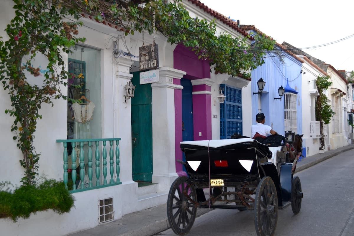 Casa colonial privada con fachada colorida en calle histórica de Cartagena de Indias con carruaje tradicional