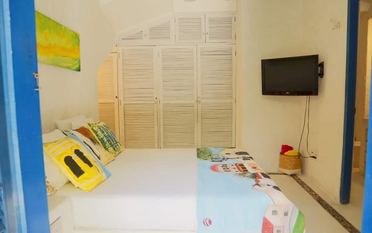 Habitación privada con cama doble, televisión y closet blanco en casa de Cartagena de Indias