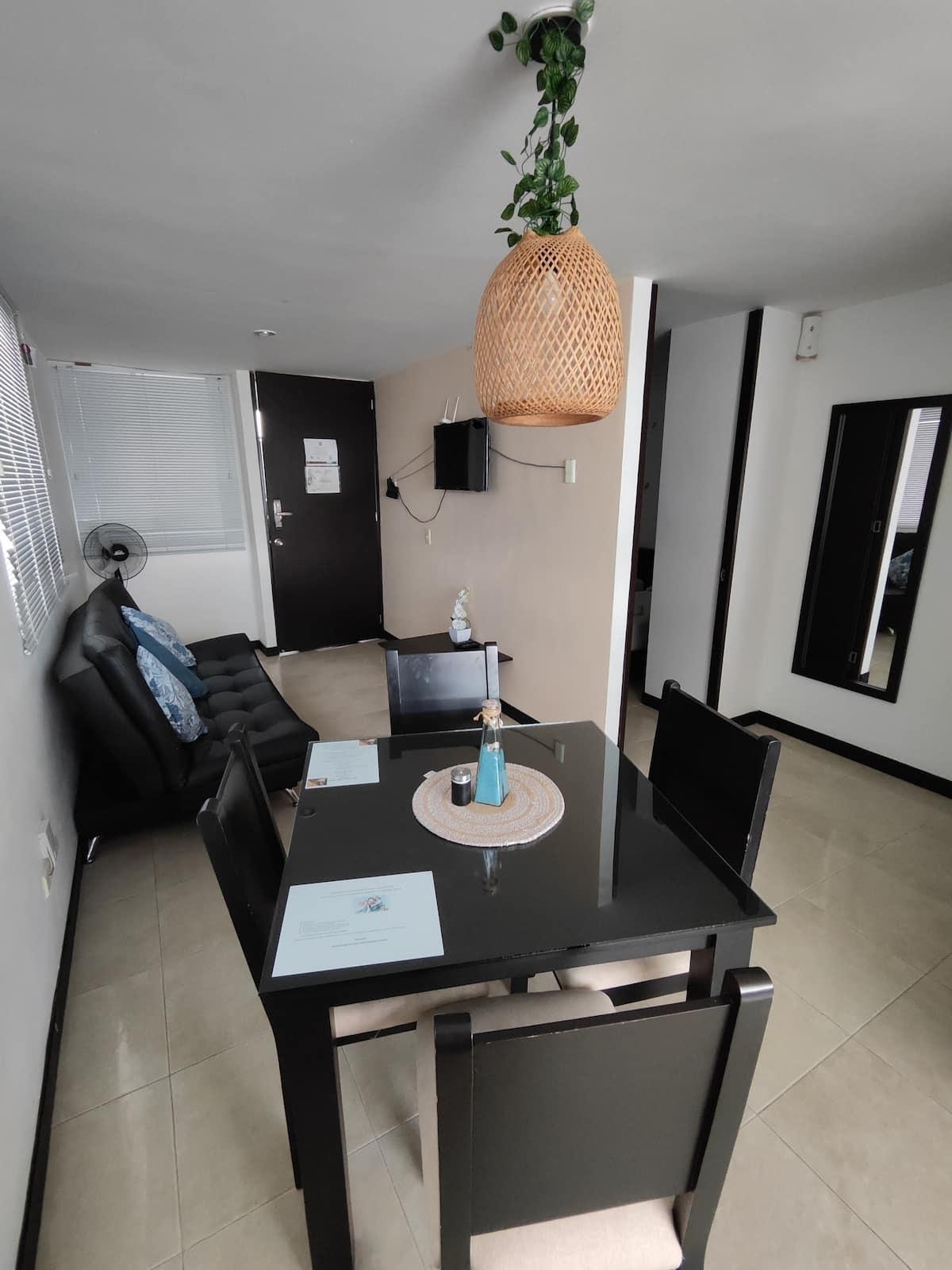 Sala comedor moderna con mesa negra y sofá en apartamento vacacional Montenegro cerca parque del café