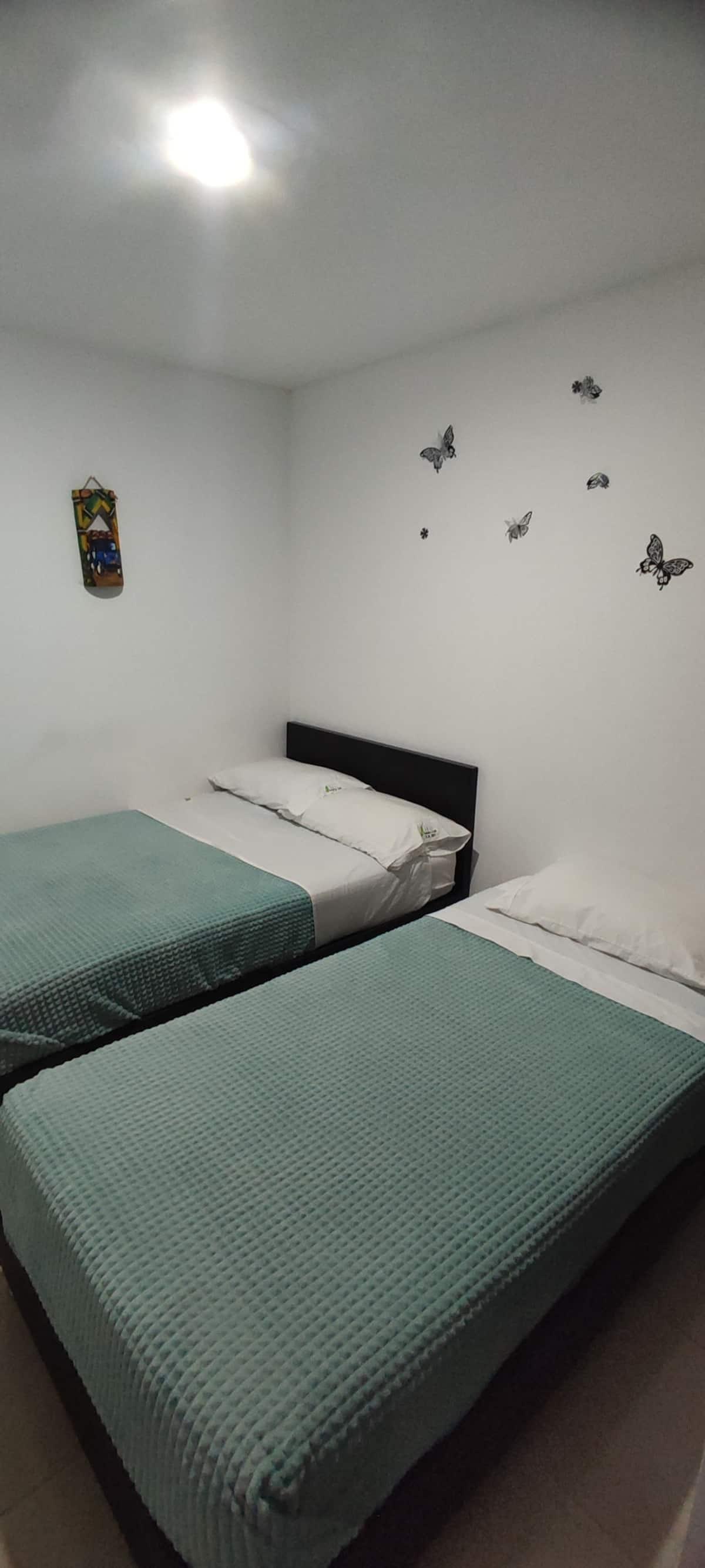 Habitación doble con dos camas individuales y decoración de mariposas en apartamento vacacional Montenegro