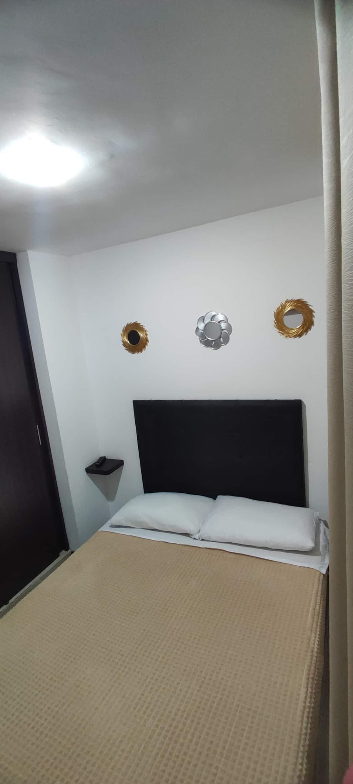 Habitación moderna con cama doble y decoración elegante en apartamento vacacional Montenegro Quindío