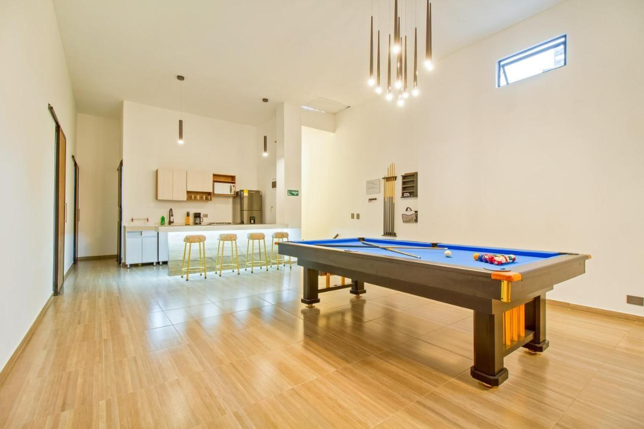 Zona social moderna con mesa de billar y cocina integral en apartamento de lujo Medellín