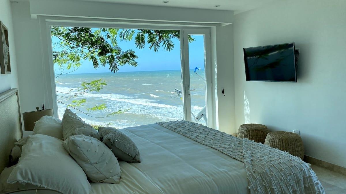 Habitación principal con cama matrimonial y vista directa al mar en casa playera Juan de Acosta