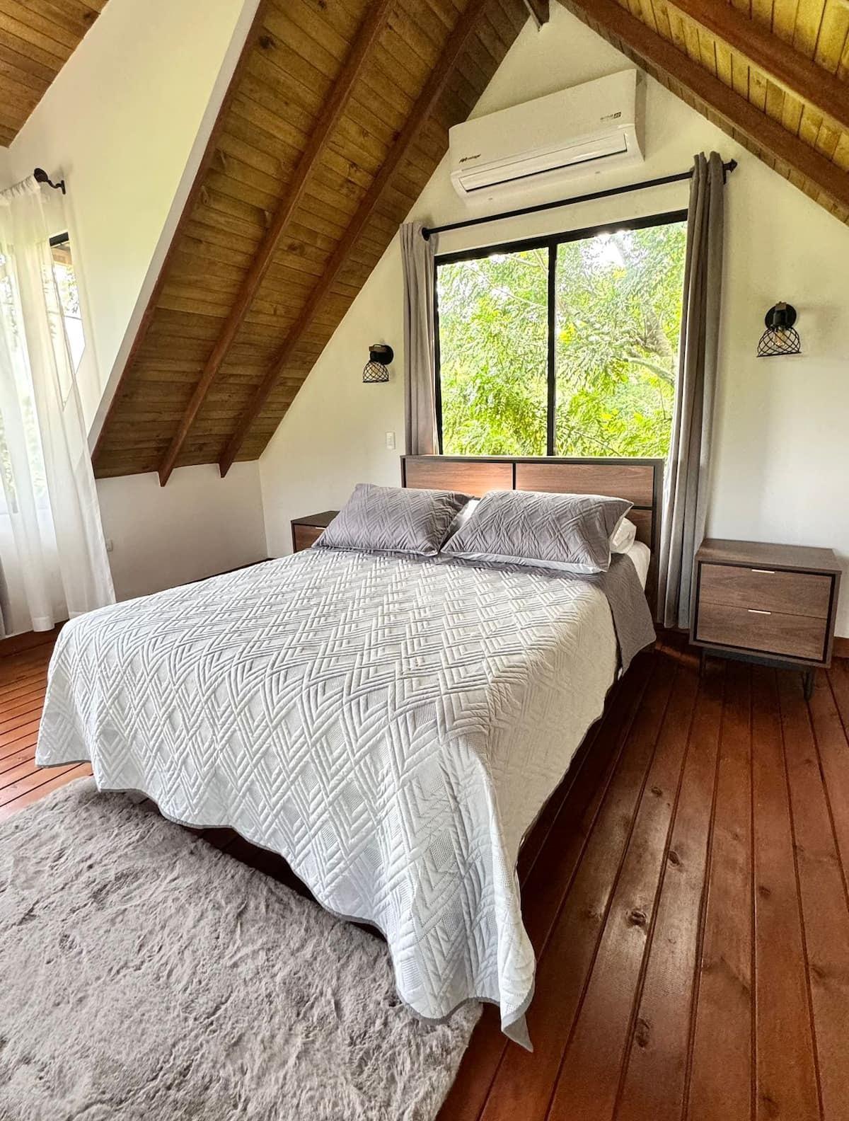 Habitación principal de cabaña en Girardota con aire acondicionado, cama matrimonial y vista al bosque