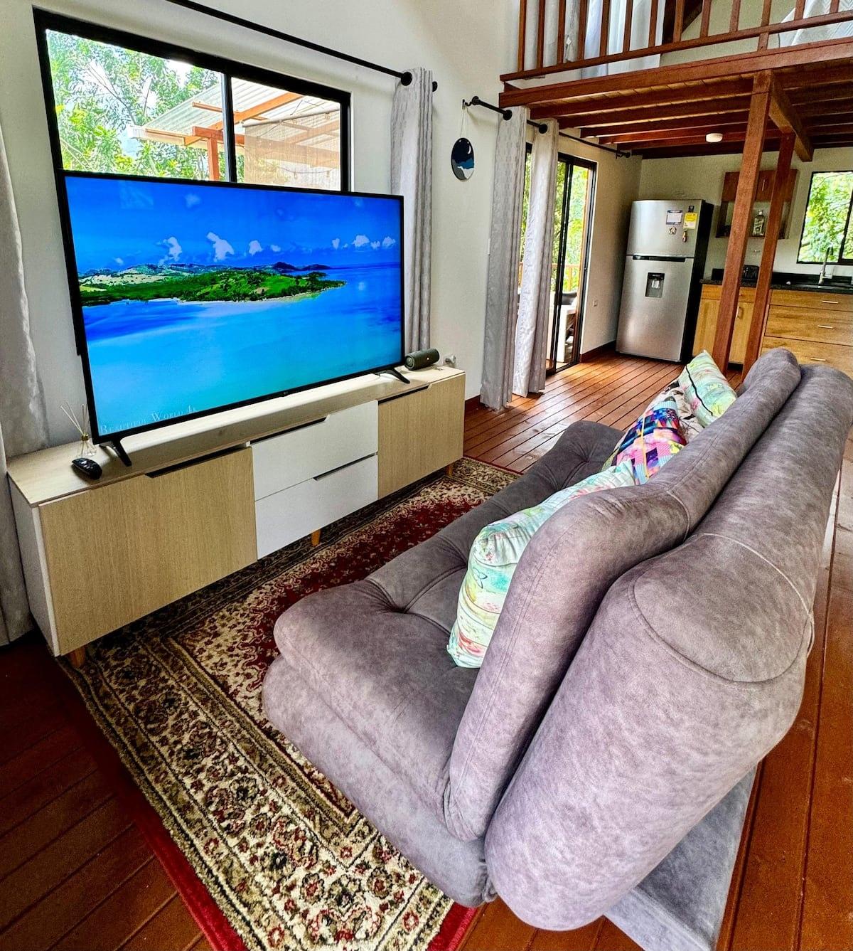 Sala de estar con TV grande y sofá cómodo en cabaña de Girardota con aire acondicionado