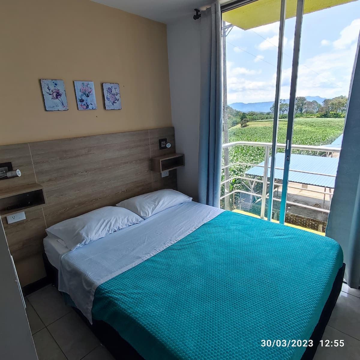 Habitación con cama doble y vista panorámica a montañas desde casa en Montenegro Quindío