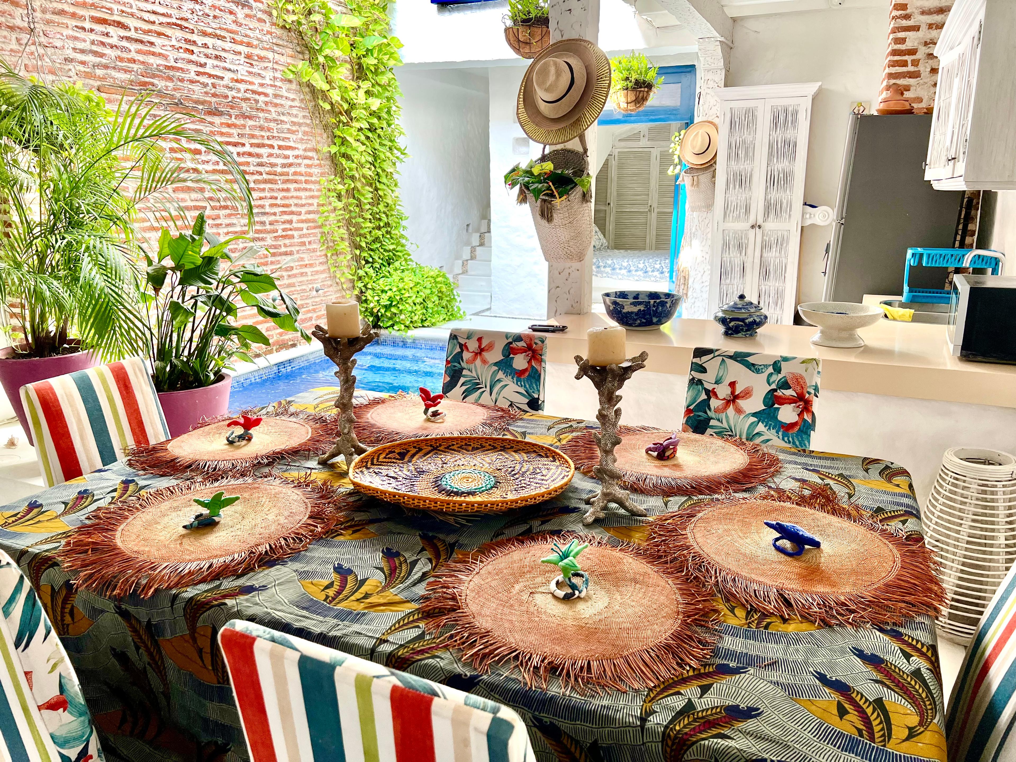 Comedor tropical con mantelería artesanal y decoración caribeña en casa privada de Cartagena de Indias