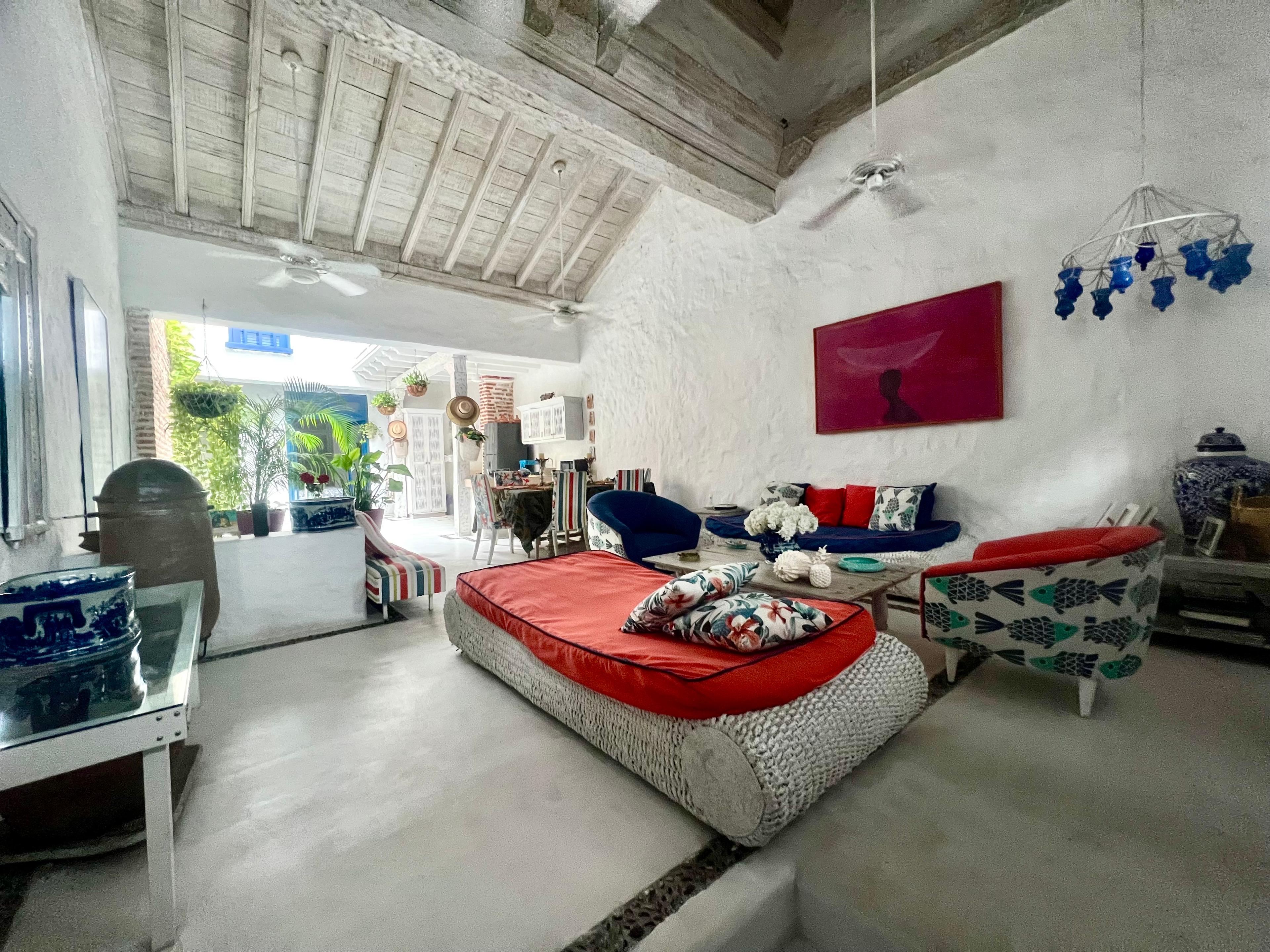 Sala moderna con decoración tropical en casa privada de Cartagena de Indias con muebles coloridos