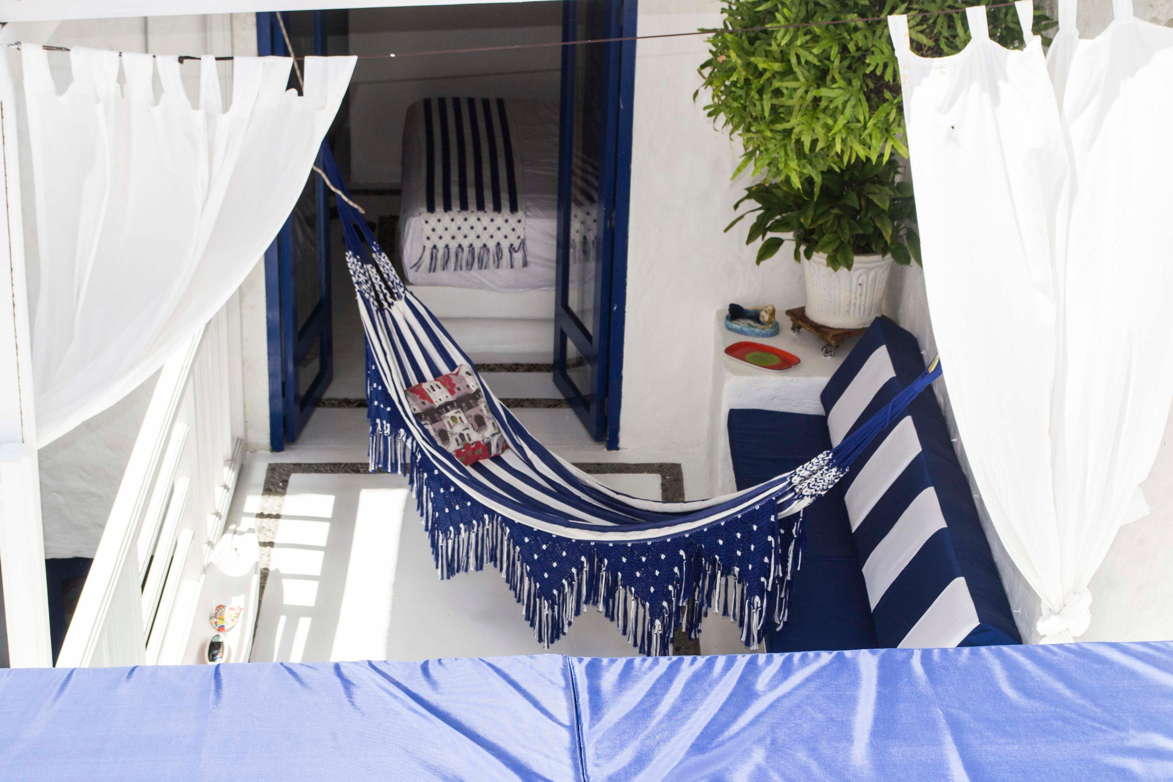 Terraza con hamaca azul y blanca en casa privada de Cartagena de Indias con plantas decorativas