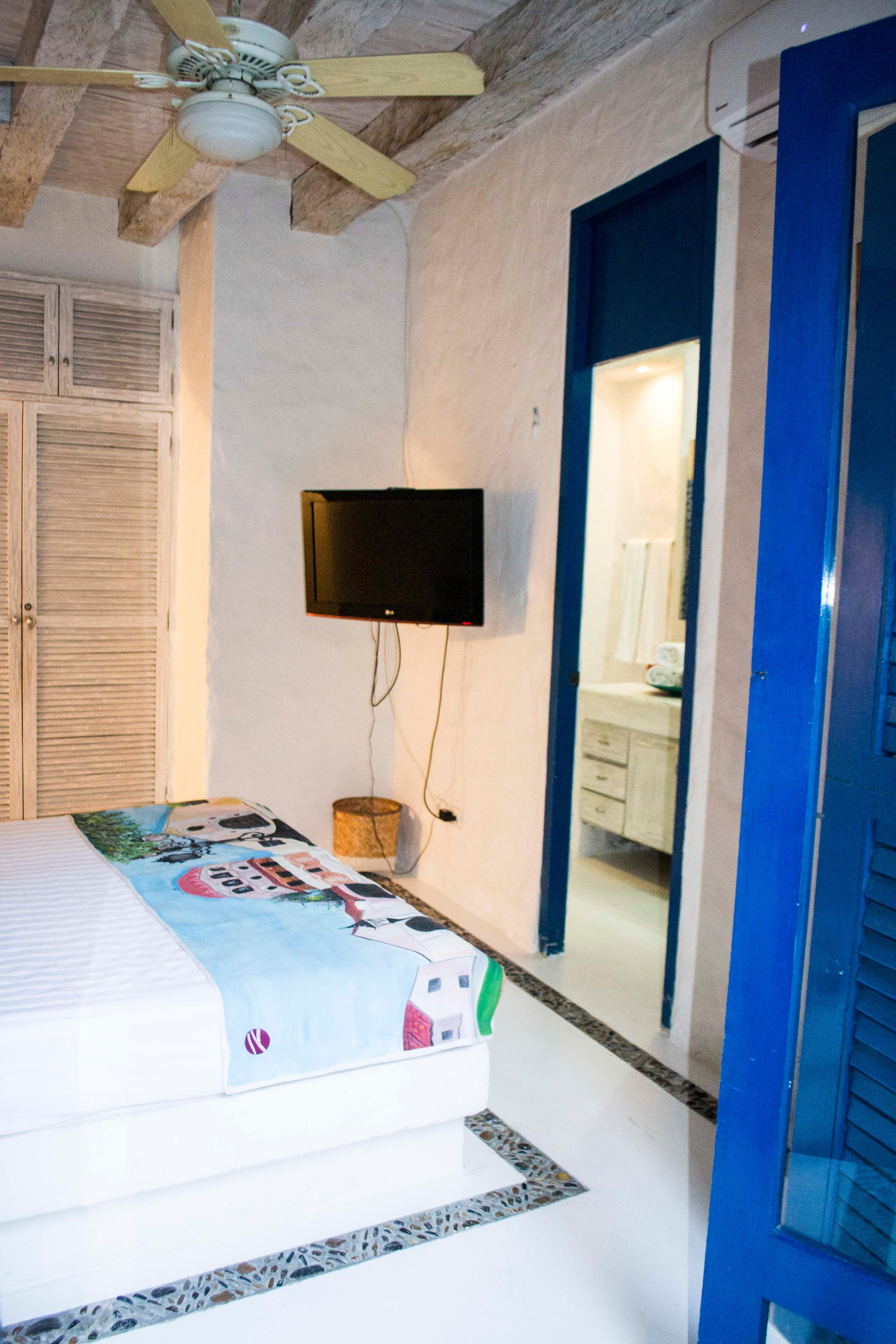 Habitación privada con cama doble, televisión y baño en suite en casa colonial de Cartagena de Indias