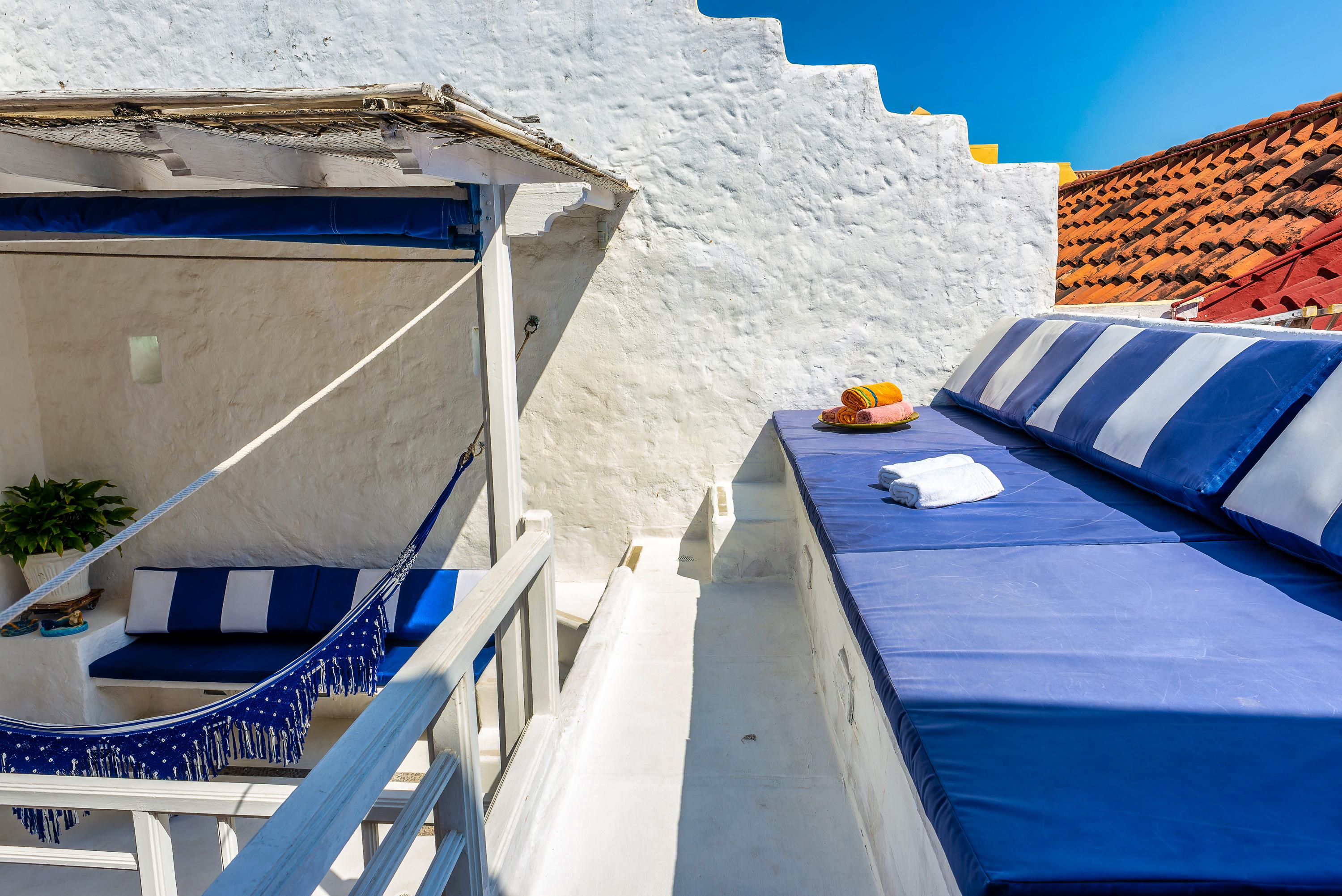 Terraza privada con hamaca y cojines azules en casa colonial de Cartagena de Indias