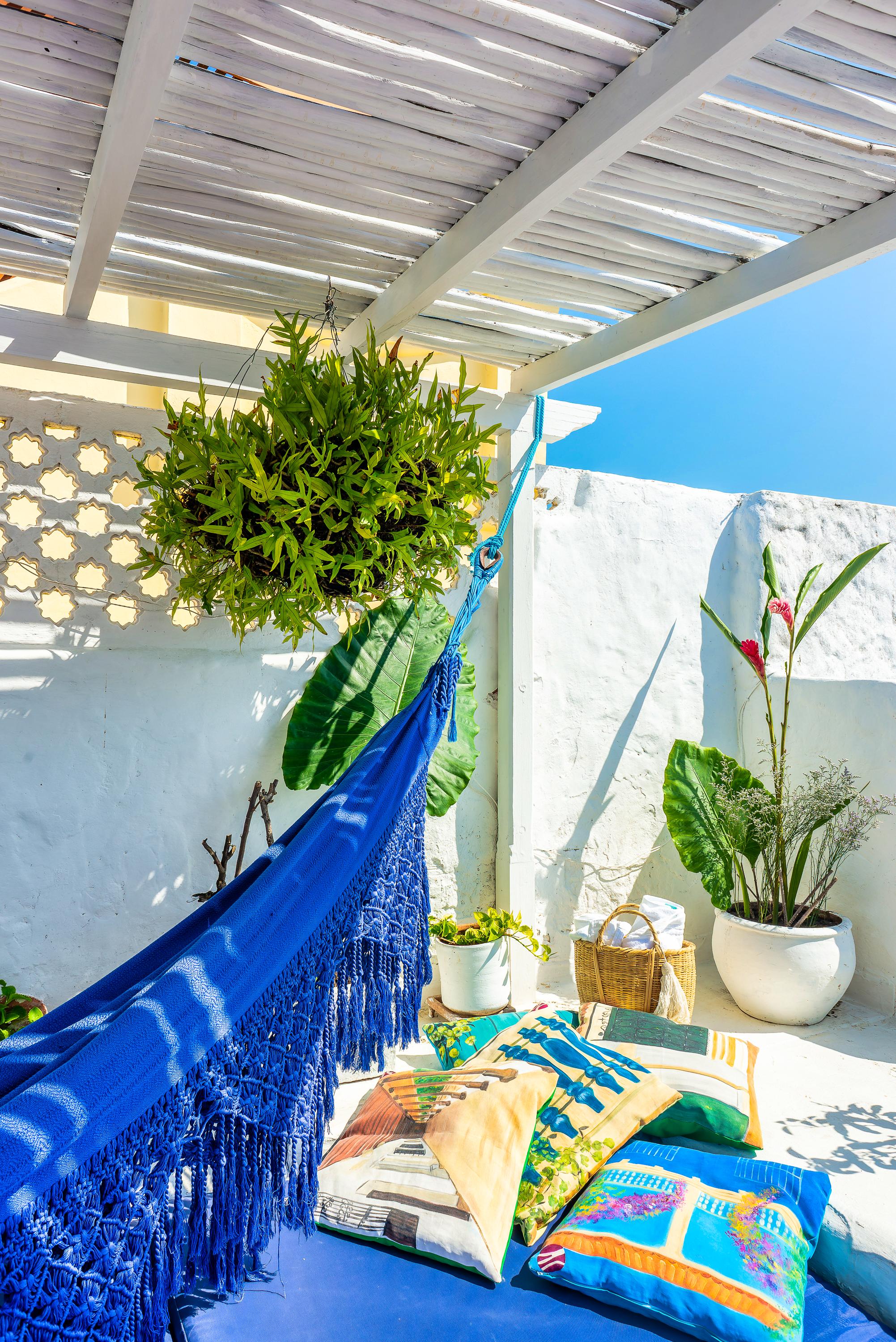 Terraza relajante con hamaca azul y plantas tropicales en casa privada de Cartagena de Indias