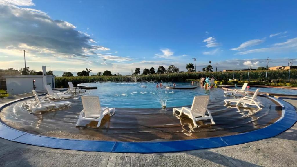 Piscina circular con sillas blancas en complejo residencial de apartamento en Montenegro cerca del Parque del Café