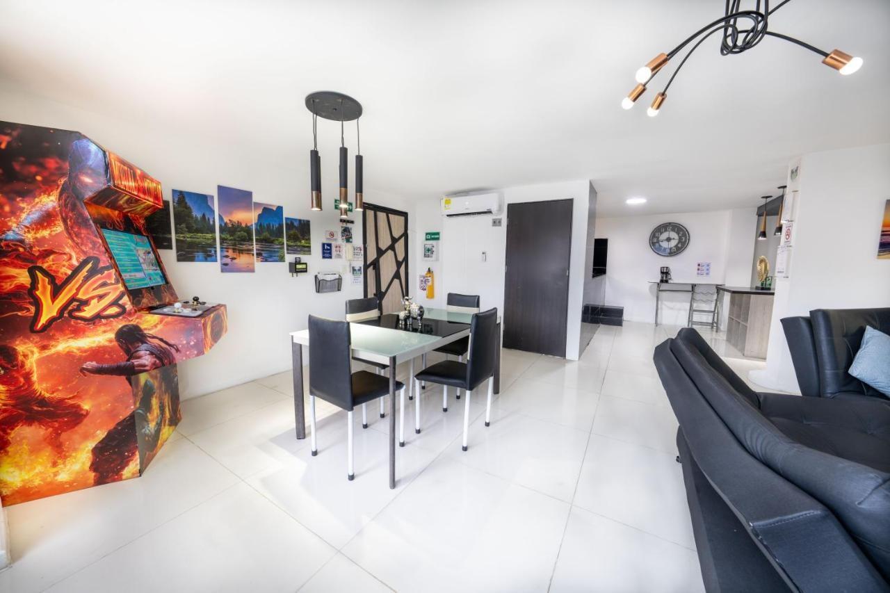 Sala comedor moderna con sofá negro y mesa de vidrio en apartamento Medellín cerca Parque Lleras