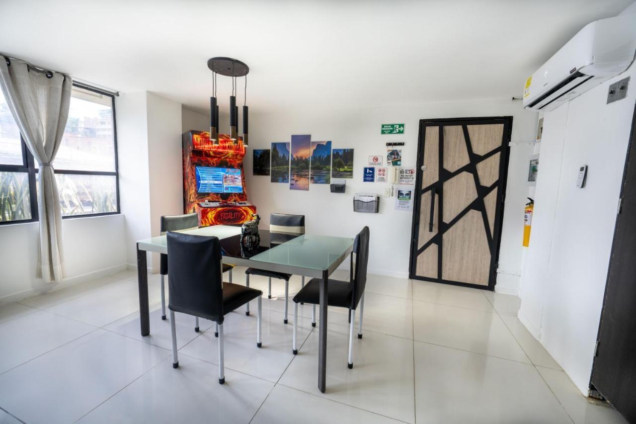Comedor moderno con mesa de vidrio y sillas negras en apartamento de Medellín cerca Parque Lleras