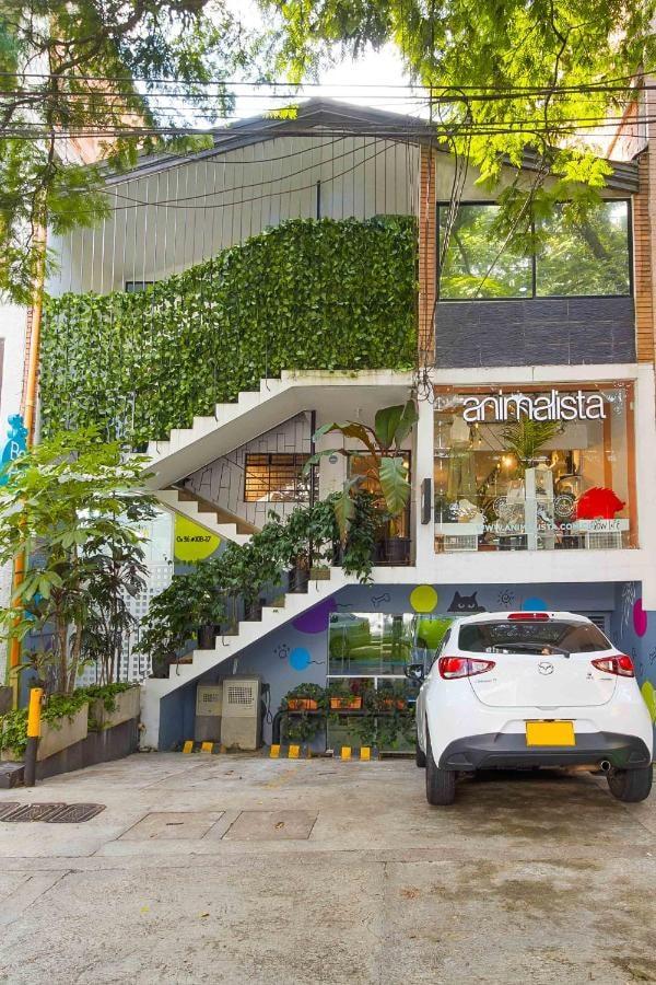 Fachada moderna de apartamento con parqueadero cubierto y vegetación en Provenza, Medellín