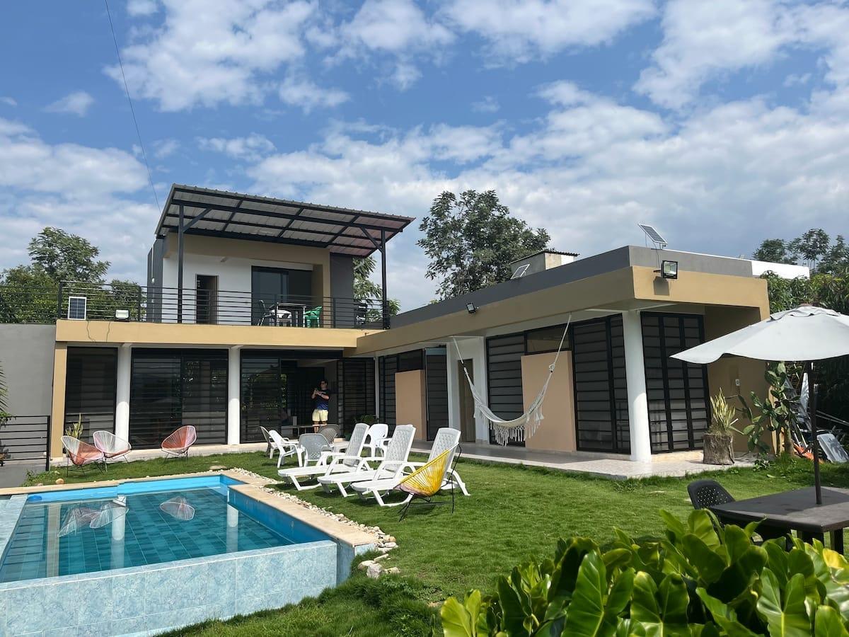 Casa tropical con piscina, terraza amplia, hamaca y jardín verde en Apulo Colombia