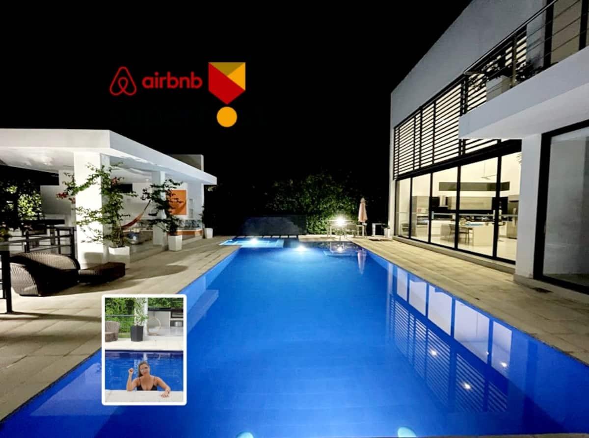 Piscina iluminada de noche en casa vacacional con terraza y zona social en Apulo