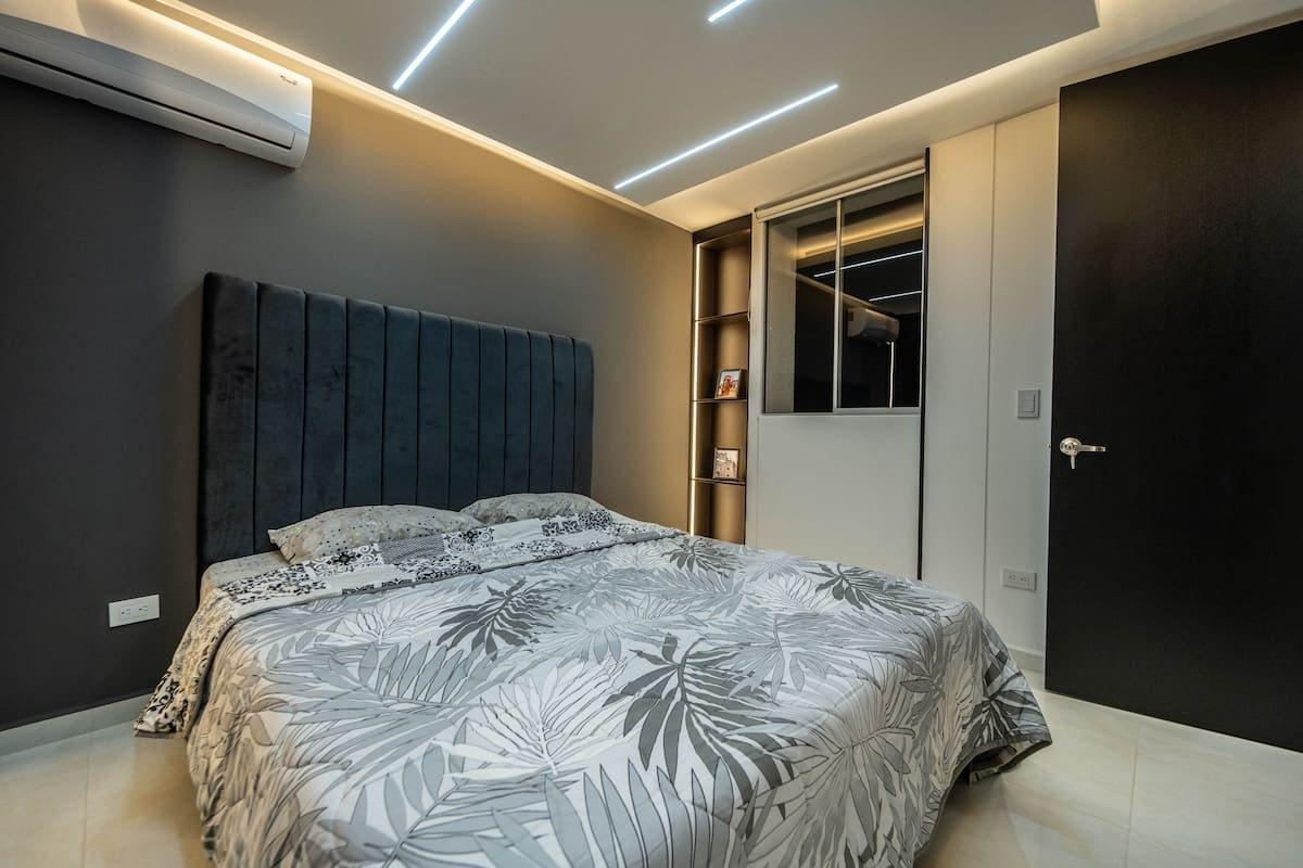 Habitación principal moderna con cama doble y iluminación LED en apartamento inteligente de Cúcuta
